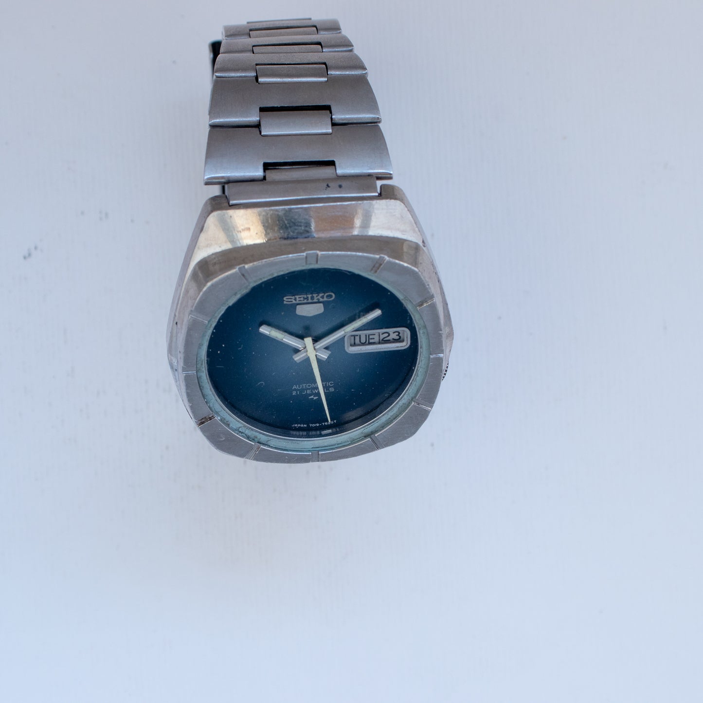 Silver Seiko watch with blue face on a white background